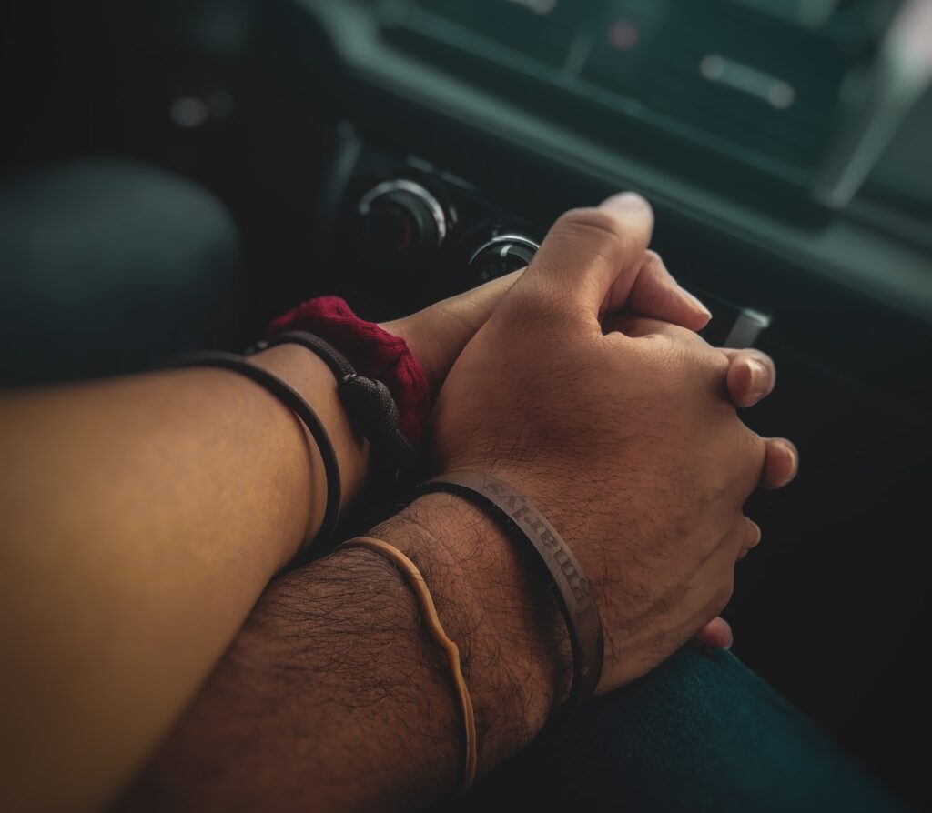 couple holding hands in the car