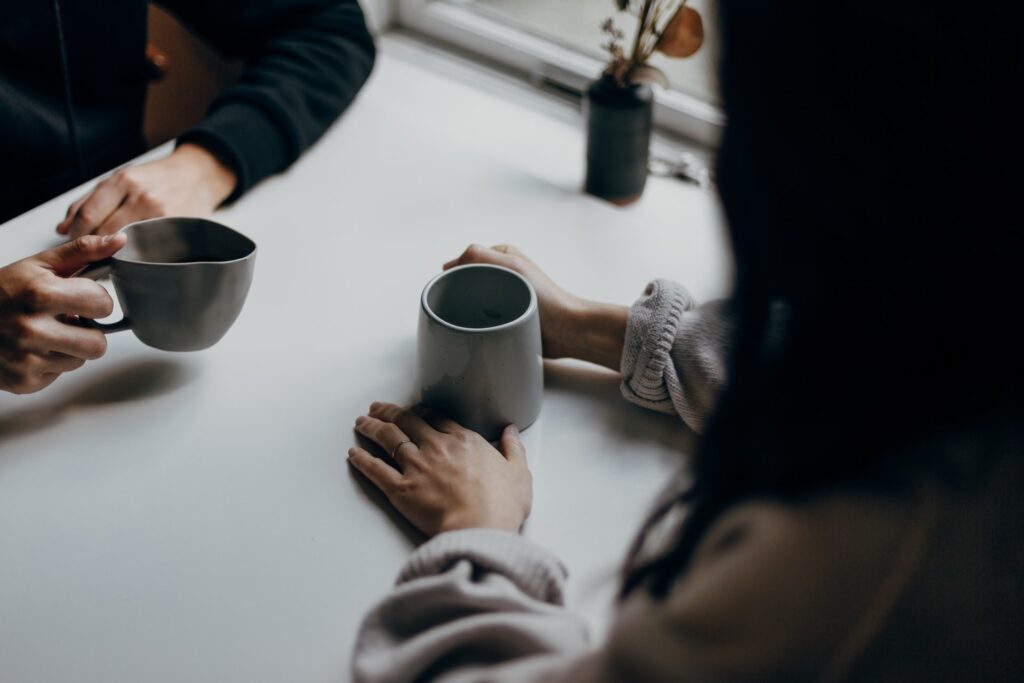young women sharing coffee at a small table